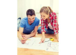 repair, building, renovation and home concept - smiling couple looking at blueprint at home